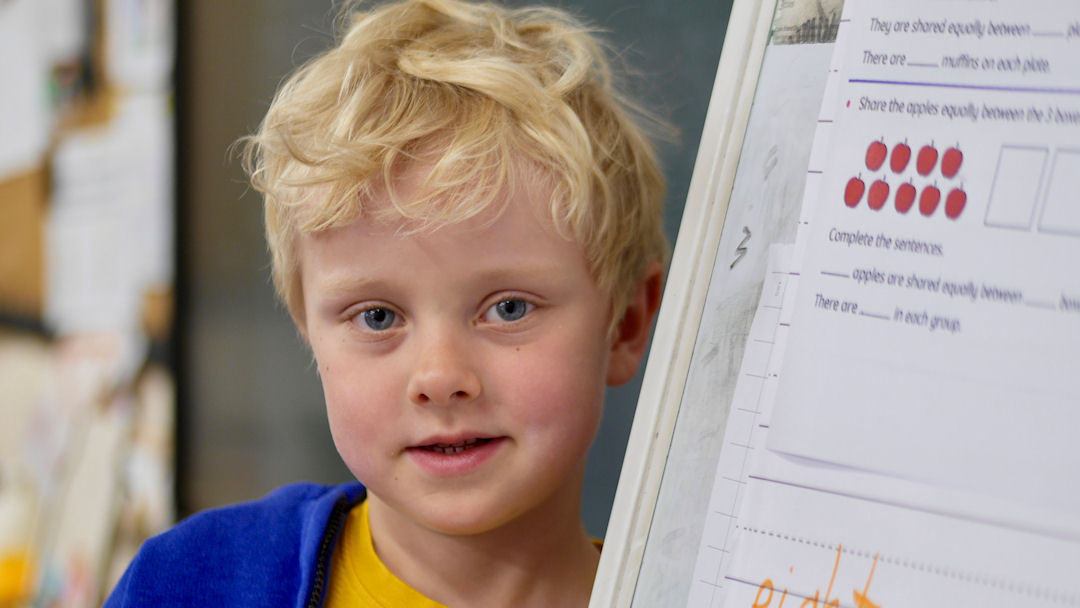 A school child standing next to a display board